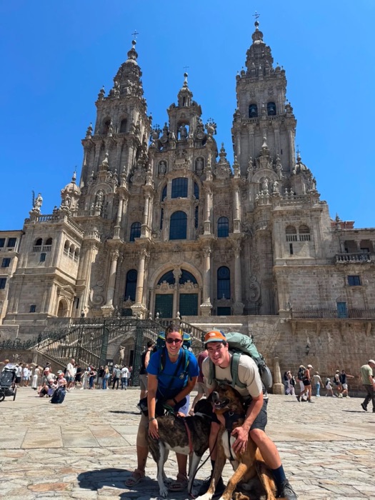 Pareja con su perro tras completar el Camino de Santiago